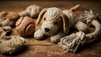 Vintage worn teddy bears and soft toys scattered on rustic wooden surface creating nostalgic childhood memories atmosphere for emotional storytelling concepts.