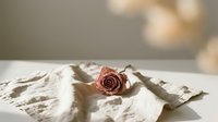 Dried rose on vintage letters with soft natural lighting creating romantic nostalgic atmosphere for wedding invitations greeting cards scrapbooking projects.