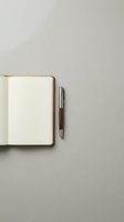Open notebook with blank cream pages and wooden pen on neutral gray background, ready for writing, planning, journaling, or business use.