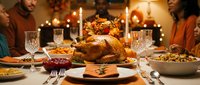 Thanksgiving dinner table with roasted turkey, side dishes, candles and family gathering for traditional holiday feast celebration.