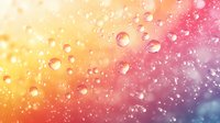 Transparent water drops on colorful gradient background with yellow, orange, pink and purple hues create dreamy bokeh effect for creative design projects.