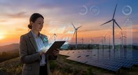 Asian businesswoman using tablet at renewable energy farm with wind turbines and solar panels during sunset for sustainable technology projects.