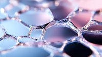 Macro photography of soap bubble structure with pink and blue gradient background showing delicate hexagonal patterns and light reflections in liquid surface.