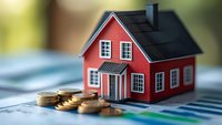 Red miniature house model with stacked coins on financial documents and charts, representing real estate investment, mortgage, and property market concepts.