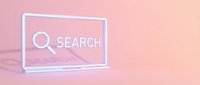 Minimalist laptop with search bar and magnifying glass icon on pastel pink background, symbolizing online search and digital technology.