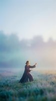 Woman practicing tai chi in misty morning field with soft pastel sky and ethereal atmosphere for wellness and mindfulness concepts.