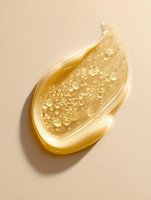 Golden honey drop with air bubbles on beige background, macro photography showing transparent texture and natural sweetness for food and cosmetic designs.