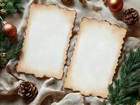 Vintage burnt paper sheets with blank space for text, surrounded by pine cones, Christmas ornaments and evergreen branches on fabric background.