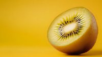 Fresh kiwi fruit half showing seeds and flesh on vibrant yellow background for healthy eating and nutrition concepts.