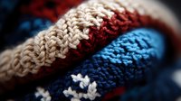 Macro close-up of knitted wool texture in beige, red and blue colors showing detailed yarn pattern and stitches structure, suitable for winter fashion backgrounds.