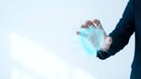 Businessman in dark suit holding glowing blue shield symbol representing data protection, cybersecurity, and digital safety for business and technology concepts.