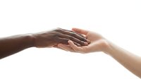 Two diverse hands gently touching, symbolizing unity, support, and human connection against a clean white background.