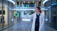 Female doctor in white coat interacting with holographic medical interface displaying molecular structures in modern hospital corridor with futuristic technology.