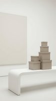 Stacked kraft cardboard boxes in various sizes arranged on white platform against neutral background for packaging, shipping, storage and logistics design projects.