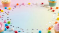 Colorful party celebration background with confetti, cupcakes and decorative elements creating festive frame with copy space for text or design projects.