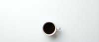 Black coffee in white ceramic mug on clean white background, minimalist flat lay composition for morning beverage concepts and cafe branding materials.