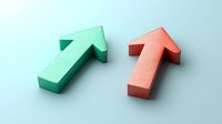 Two directional arrows in mint green and coral pink colors cast soft shadows on light background, representing choice, direction, or business decisions.