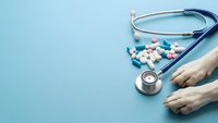 Medical stethoscope with colorful pills and capsules on blue background. Healthcare concept for pharmacy, medicine and treatment applications.