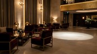 Elegant hotel lobby interior with luxury leather armchairs, warm lighting, marble floors and sophisticated decor for hospitality design projects.