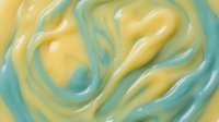 Smooth flowing abstract swirls in soft yellow and mint green colors creating organic fluid motion patterns for modern design backgrounds.