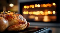 Roasted turkey with golden crispy skin cooking on oven rack with warm bokeh lights in background creating festive holiday atmosphere for family dinner.