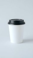 White disposable coffee cup with black lid isolated on gray background for cafe branding and takeaway beverage mockup designs.