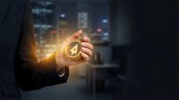 Businessman hand holding glowing compass in dark office with city lights background showing direction guidance and leadership concept for business strategy.