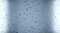 Water droplets on glass surface creating natural condensation pattern with blue-gray tones for backgrounds and textures.