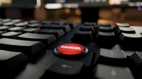 Red danger button on black computer keyboard in office environment highlighting cybersecurity threats and digital risk management concepts.