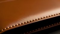 Brown leather material with detailed stitching showcasing craftsmanship and texture for luxury goods and fashion accessories manufacturing.