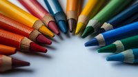 Vibrant colored pencils arranged in curved formation against white background, creating rainbow spectrum with sharp tips pointing inward, macro photography with selective focus.