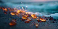 Amber sea glass pieces scattered on wet beach sand at sunset with soft bokeh lights and gentle waves in background creating romantic coastal atmosphere.