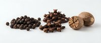 Aromatic spices collection with black peppercorns, cloves and whole nutmeg on white background for culinary cooking and seasoning recipes.
