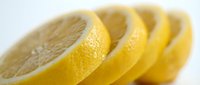 Fresh lemon slices arranged in a row, showcasing vibrant yellow color and juicy texture, perfect for food, health, and nutrition projects.