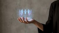 Businessman in dark suit holding glowing holographic digital avatars above palm, representing virtual team, remote workforce, digital transformation, metaverse technology and future communication.
