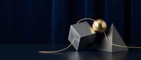 Elegant black and white gift box with gold sphere ornament and ribbon on dark blue background, suitable for luxury holiday and celebration designs.