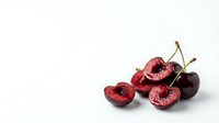 Fresh ripe cherries with cut halves showing red flesh and pits on clean white background isolated for healthy food design and culinary projects.