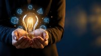 Businessman holding glowing light bulb with floating geometric shapes representing innovation, creativity and business ideas for technology solutions.