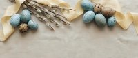 Easter eggs with pussy willow branches and ribbon on wooden background for spring holiday decoration and greeting cards.