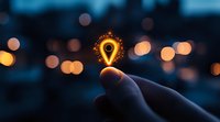 Glowing location pin icon held between fingers against blurred city lights background, representing digital navigation and smart city technology concept.