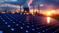 Solar panel array at industrial zone during dramatic sunset with factory chimneys and smoke silhouettes against orange sky, renewable energy concept.
