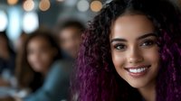 Young African American woman with vibrant purple curly hair smiling confidently at camera, with soft bokeh lights and blurred people in background, expressing joy and authenticity.