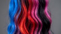 Colorful hair extensions or wigs displaying vibrant blue, red, pink, and black shades with wavy texture, suitable for beauty, fashion, and salon design projects.