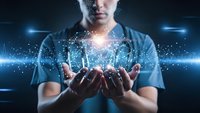 Young professional man holding glowing digital brain with network connections in cupped hands representing artificial intelligence and innovation.