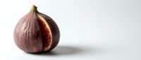 Fresh ripe fig cut in half showing red flesh and seeds on white background isolated for healthy food design and culinary projects.