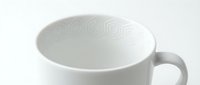 White ceramic mug with subtle hexagon geometric pattern on interior rim, minimalist design on light background, top view angle.