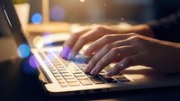 Close-up of female hands typing on a laptop keyboard with glowing bokeh lights, symbolizing digital work and online connectivity.