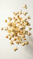 Popped corn kernels and unpopped seeds falling through air on neutral background for snack food advertising and culinary design projects.