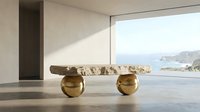 Modern stone coffee table with golden spherical legs in minimalist living room overlooking ocean view through floor-to-ceiling windows.