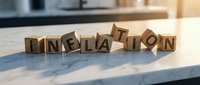 Wooden letter blocks spelling INFLATION arranged on a marble surface, symbolizing rising costs, economic crisis, and financial instability.